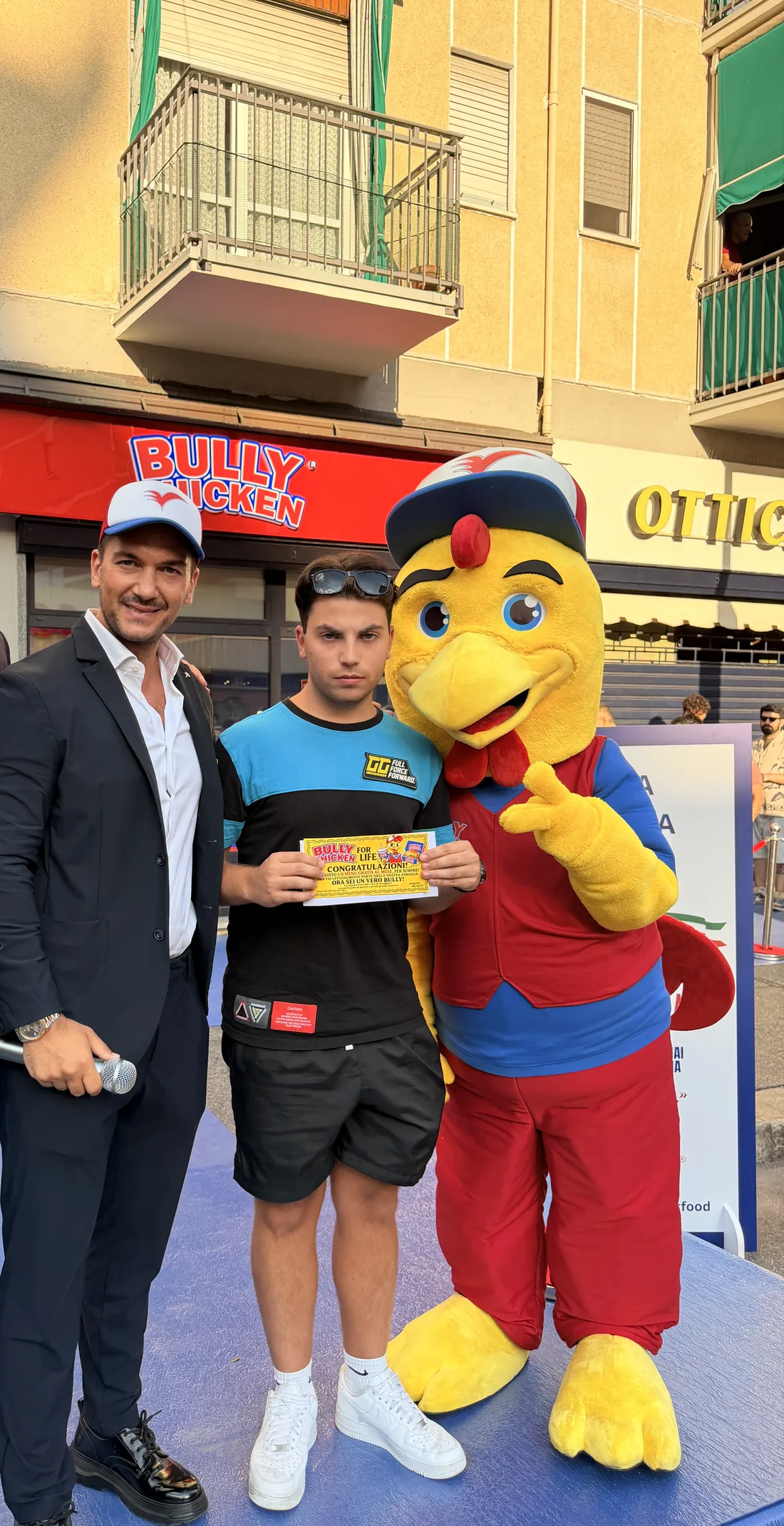Un vincitore con il Biglietto d'Oro accanto al presentatore e alla mascotte