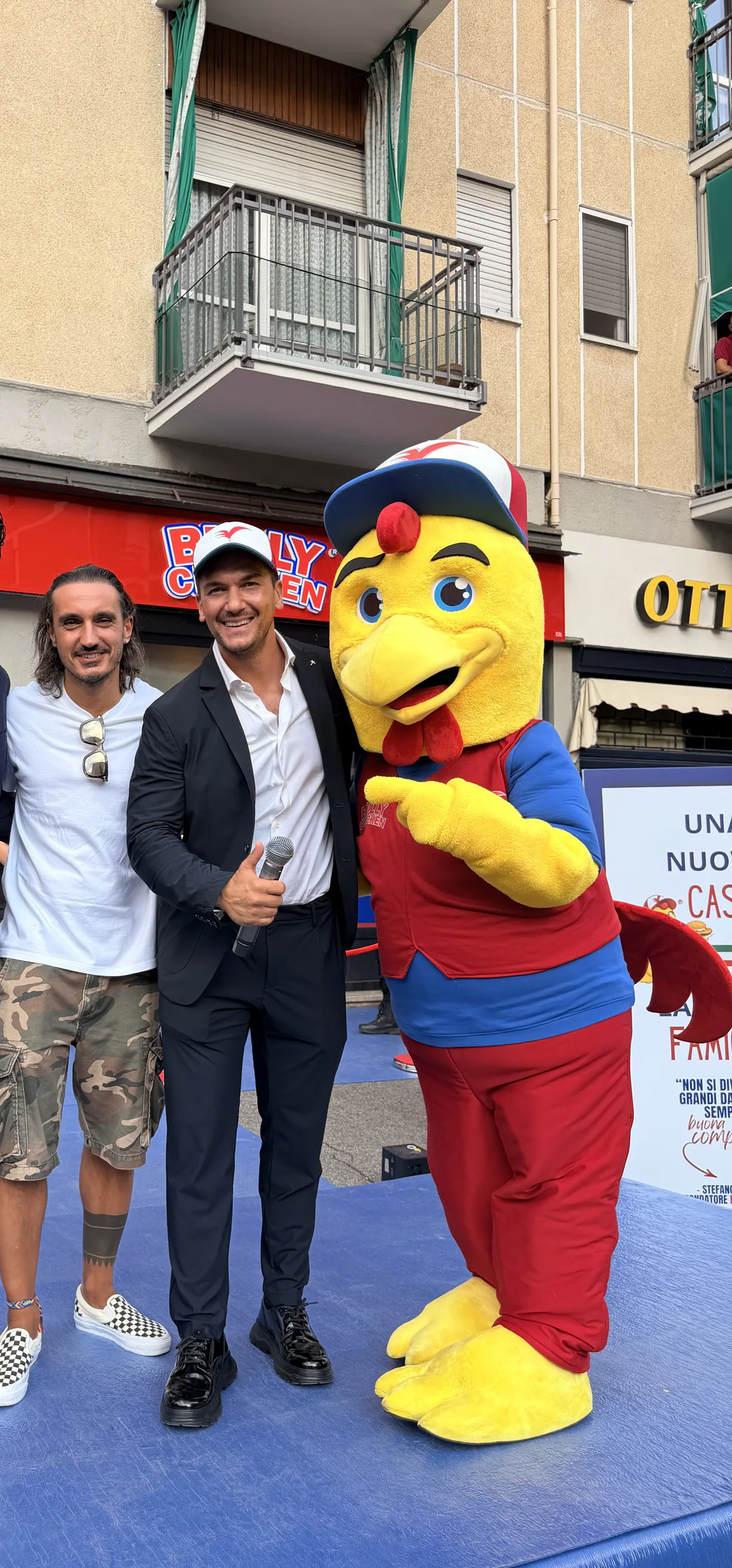 Ospiti e presentatore con la mascotte Bully Chicken sul palco blu