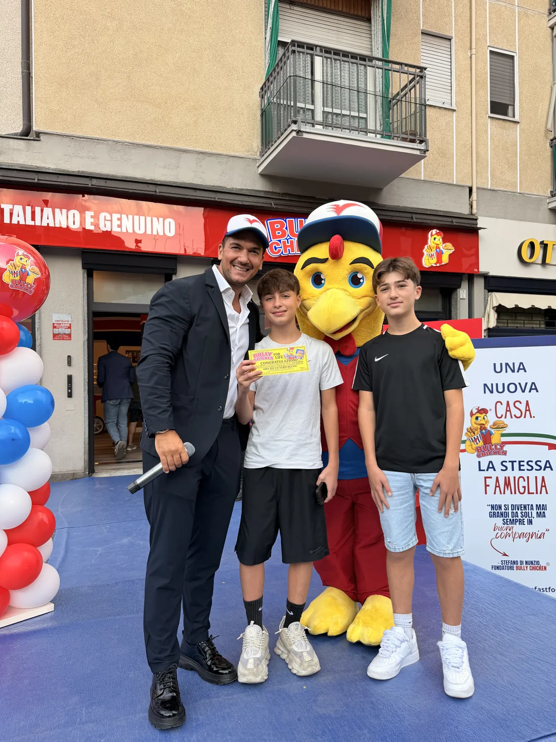 Il presentatore con due ragazzi e la mascotte Bully Chicken