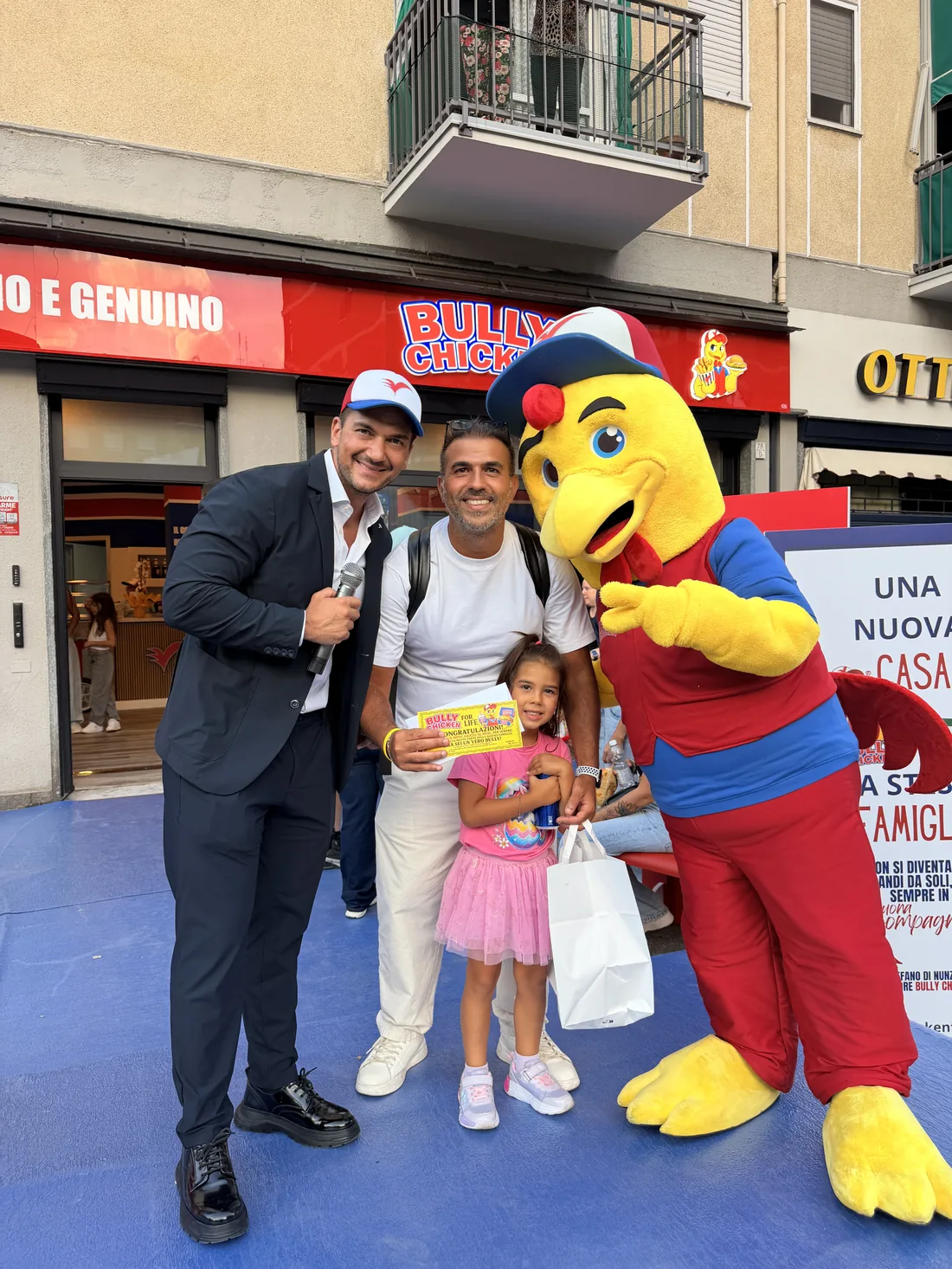 Un papà e la sua bambina con il Biglietto d'Oro accanto alla mascotte