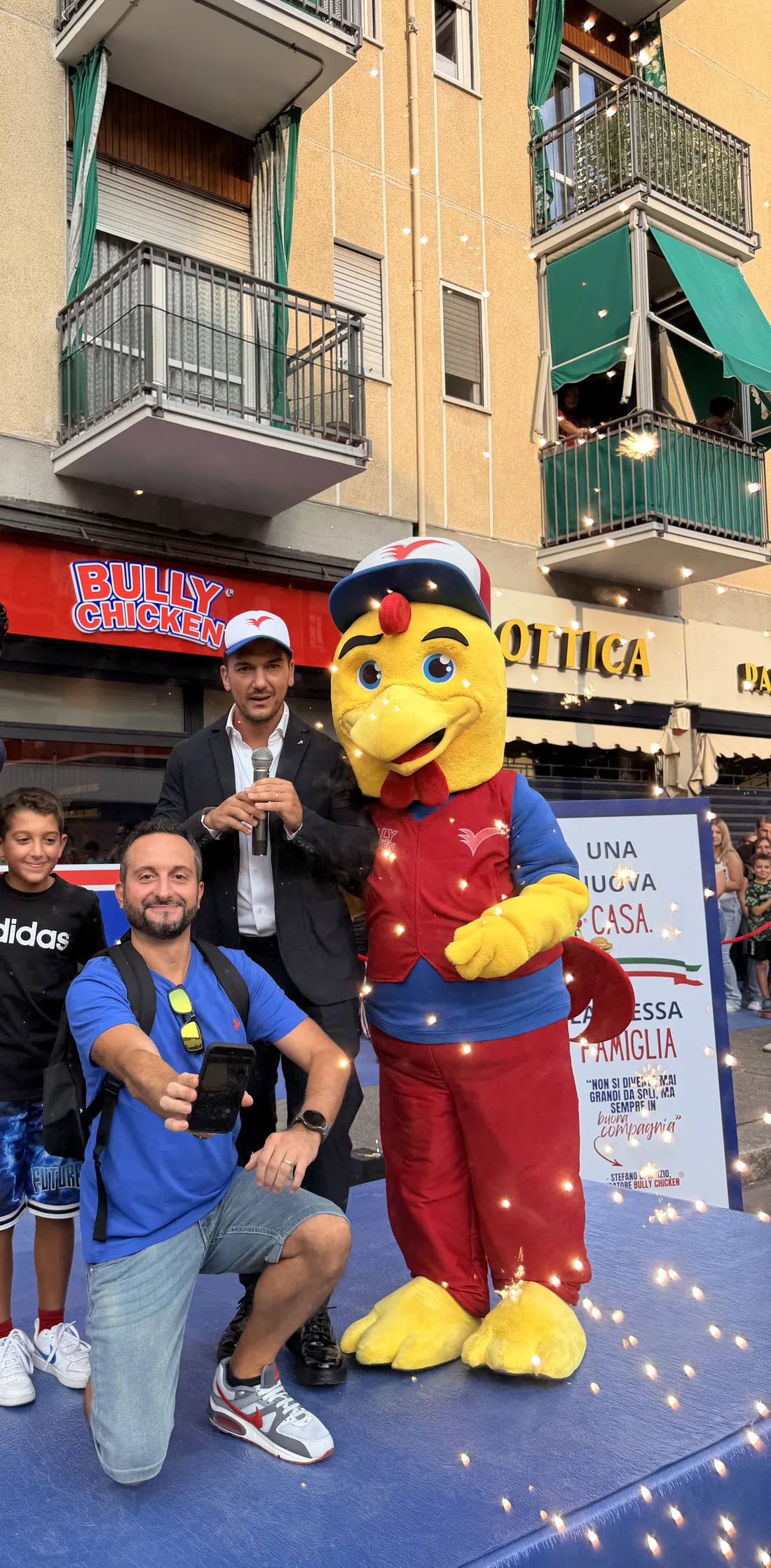 Un fotografo, il presentatore e la mascotte Bully Chicken sul palco tra le scintille