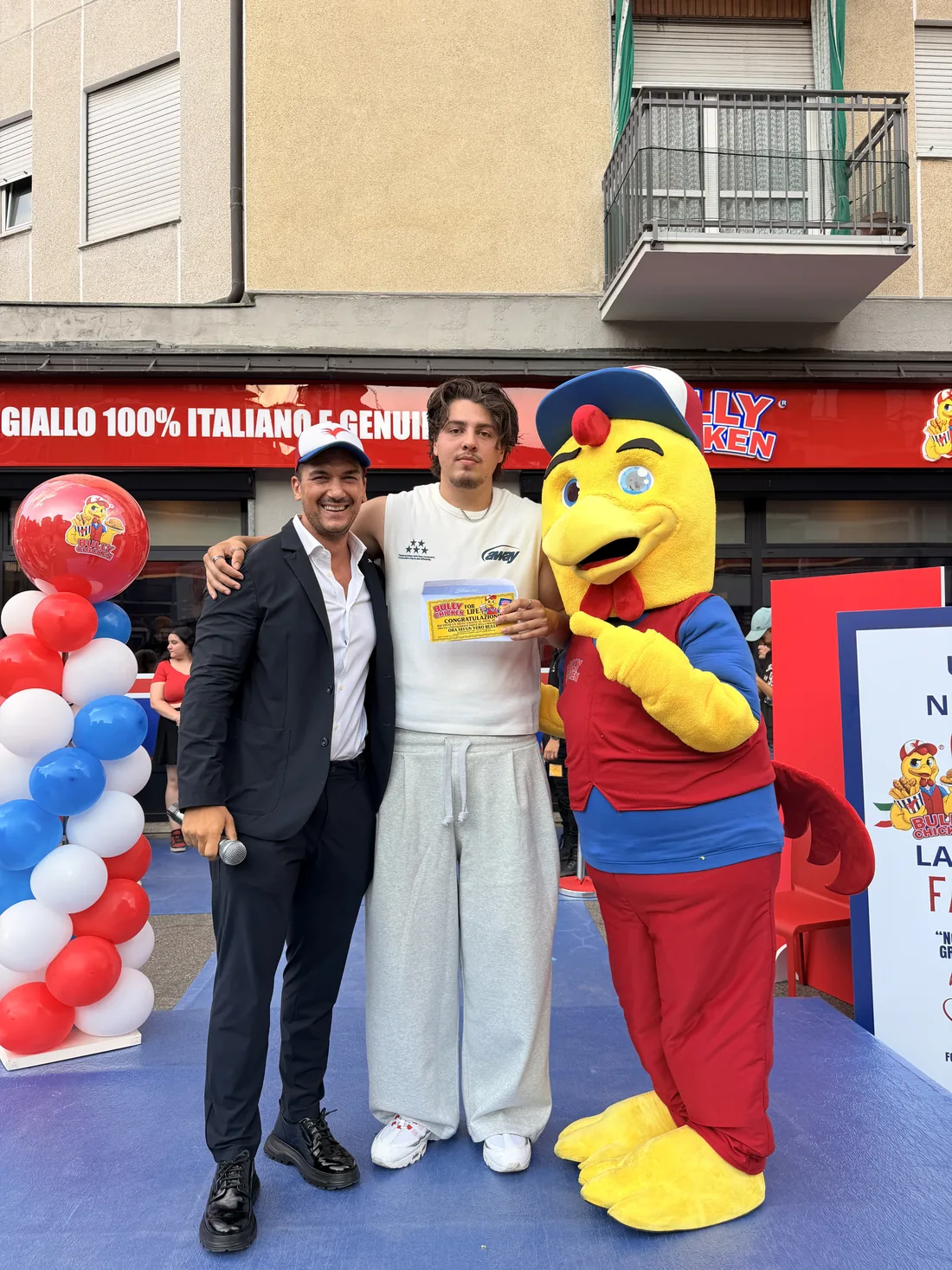 La mascotte Bully Chicken sul palco con il presentatore e un ospite con il Biglietto d'Oro